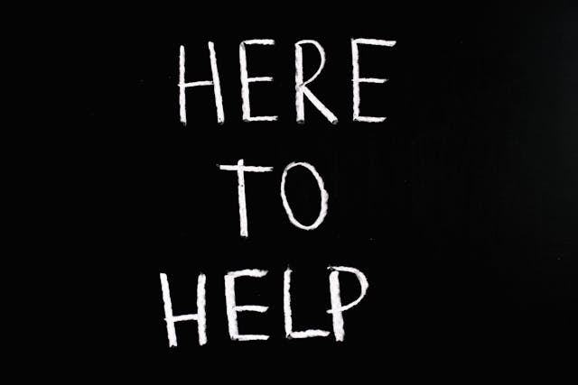 Chalkboard with "Here to Help" written on it