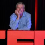 Jim Barber leaning on TEDx logo