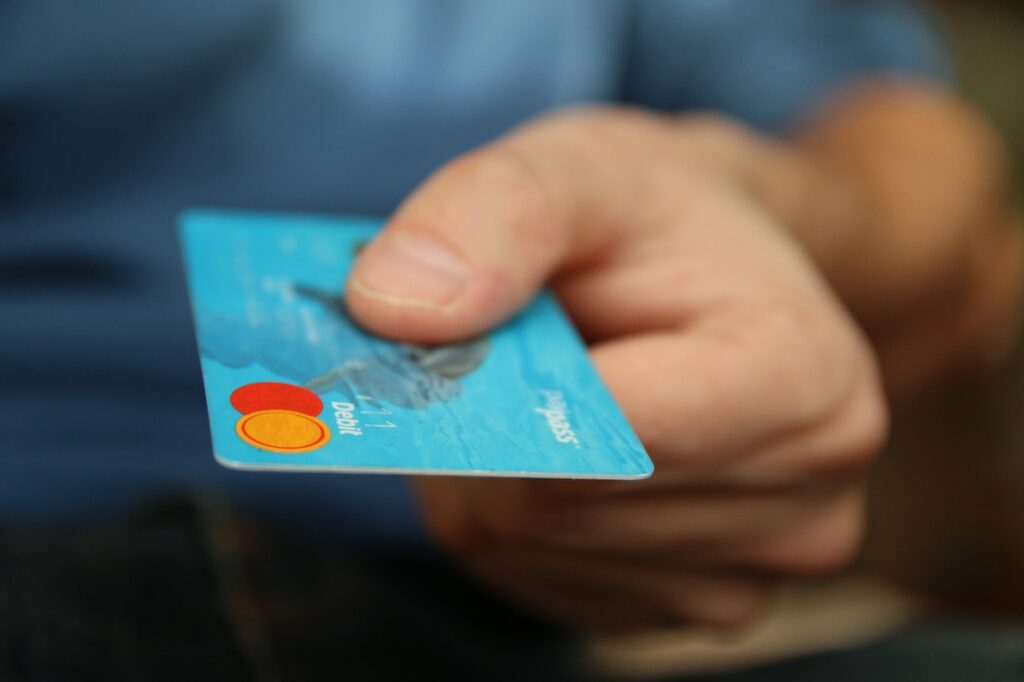 Person holding and offering credit card